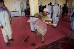 Devotees are seen inside a mosque after a bomb blast on the outskirts of Kabul, May 14, 2021, that killed at least 12 people, shattering the relative calm of a holiday cease-fire between the warring Taliban and government forces.