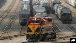 A worker climbs aboard a locomotive at a CPKC rail yard Wednesday, Aug. 21, 2024, in Kansas City, Mo.