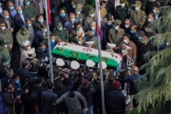 FILE - Military personnel carry the coffin of Mohsen Fakhrizadeh, an Iranian scientist killed on Friday, at a funeral in Tehran, Nov. 30, 2020.