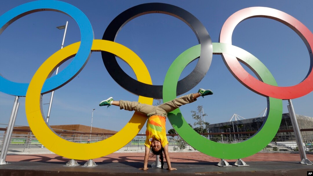 Devojčica pravi "zvezdu" ispred olimpijskih krugova u Olimpijskom parku u Riju