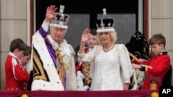Король Великої Британії Карл III і королева Камілла вітають своїх прихильників з балкона Букінгемського палацу після церемонії коронації в Лондоні, 6 травня 2023 року. (AP Photo/Frank Augstein)