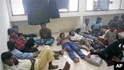 Ethnic Rohingya boat people rest after being rescued at a port in Aceh Besar, Indonesia, February 16, 2011
