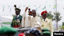 Nigeria's new President Muhammadu Buhari rides on the motorcade while inspecting the guard of honor at Eagle Square in Abuja, Nigeria, May 29, 2015. 