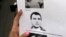 FILE- A reporter holds a picture of Antonio "Jaime" Stiusso, one of the country's most enigmatic spy chiefs, outside the prosecutor's office in Buenos Aires, Feb. 5, 2015. 
