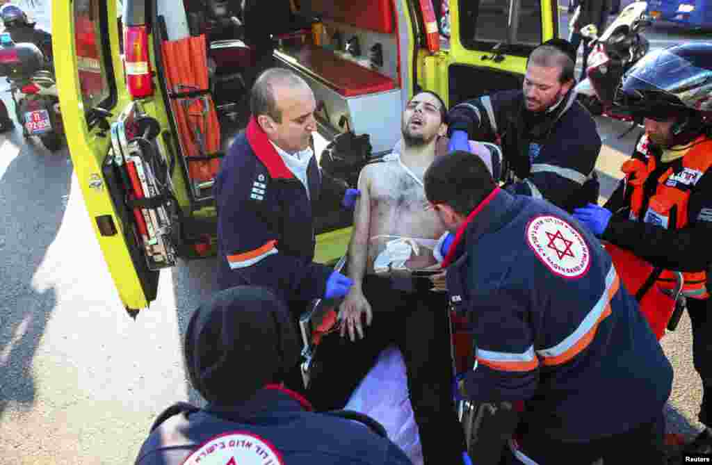 Israeli medics transport a wounded man to an ambulance at the scene of a stabbing in Tel Aviv, Jan. 21, 2015.