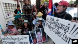 Boeung Kak lake community's land activists shout slogans with a poster of detained Tep Vanny during a rally in front of an appeals court in Phnom Penh, Cambodia, Tuesday, Aug. 8, 2017. The court upheld a 2 ½ year prison term against Tep Vanny, a prominent land rights activist on charges of committing violence at a protest she helped lead outside of Prime Minister Hun Sen's residence more than three years ago. (AP Photo/Heng Sinith)