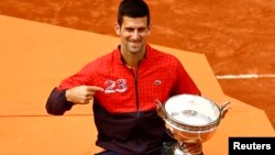 Novak Đoković sa peharom posle pobede na Rolan Garosu, 11. juna 2023. (Foto: Reuters/Clodagh Kilcoyne)