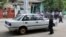 Burma police officers inspect a damaged vehicle at the scene of a small blast that happened close by the vehicle in Mandalay, July 22, 2013.
