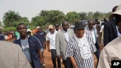 FILE - Liberian Vice-President Joseph Boakai and Presidential Candidate of the Unity Party, centre, arrives to cast his votes during a Presidential runoff election in Monrovia, Liberia, Tuesday Dec. 26, 2017.