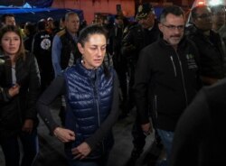 Mexico City's Mayor Claudia Sheinbaum, center, leaves Tacubaya metro station, where two trains collided leaving one dead and 41 injured, in Mexico City, March 11, 2020.