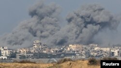 Asap mengepul di atas reruntuhan bangunan di Gaza, di tengah konflik Israel dan Hamas, terlihat dari Israel selatan, 6 Desember 2023. (Foto: REUTERS/Athit Perawongmetha)