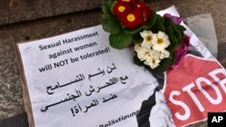 A banner with flowers is placed on the steps to the Cologne cathedral reading in English and Arabic "sexual harassment against women will not be tolerated", New Year’s Eve sexual assaults and robberies in Cologne were blamed largely on foreigners. (AP Photo/Martin Meissner)