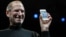 FILE - Apple CEO Steve Jobs smiles with a new iPhone at the Apple Worldwide Developers Conference in San Francisco. In the white-hot competition for tech talent, some workers are alleging Silicon Valley's top companies conspired to keep employees from switching teams, June 7, 2010.