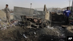 Afghan boys stand at the scene where a rocket landed in Kabul, Afghanistan, November 17, 2011.