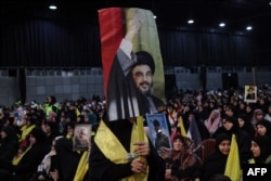 Seorang pendukung memegang potret pemimpin Hizbullah Lebanon Hasan Nasrallah pada 3 Januari 2024. (Foto: AFP)