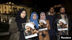 manifestantes exibem cartazes com a imagem de Nimr al-Nimr