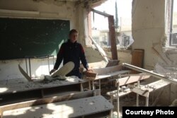 Muhammed Najem is pictured amid the rubble of his school in Eastern Ghouta, Feb. 13, 2018.