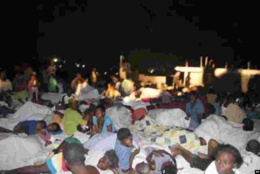 Handout photo released by the American Red Cross shows earthquake survivors gathered together in a shantytown on the outskirts of Port au Prince, Haiti, 13 Jan 2010 – AFP