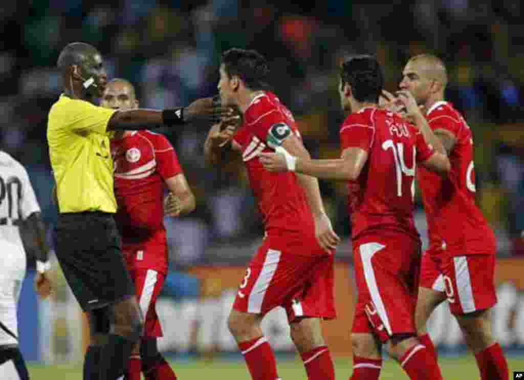 Tunisia's Karim Haggui (C) argues with referee Alioum Neant of Cameroon during their African Nations Cup quarter-final soccer match against Ghana at Franceville stadium February 5, 2012.