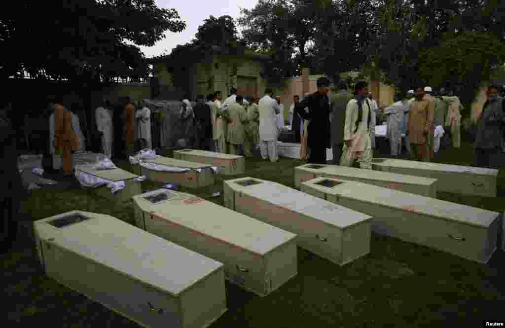 Mourners gather near the caskets of victims killed in a suicide bomb attack before funeral ceremony at a police headquarters in Quetta, Pakistan, August 8, 2013.