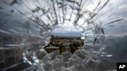 FILE - The city of Mekele is seen through a bullet hole in a stairway window of the Ayder Referral Hospital, in the Tigray region of northern Ethiopia, May 6, 2021. Ethiopian military airstrikes hit the capital of the country's Tigray region Oct. 18, 2021