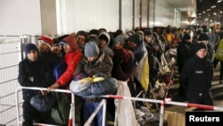 Migrants queue on a street to enter the compound outside the Berlin Office of Health and Social Affairs (LAGESO) for their registration process in Berlin, Germany, Dec. 9, 2015.