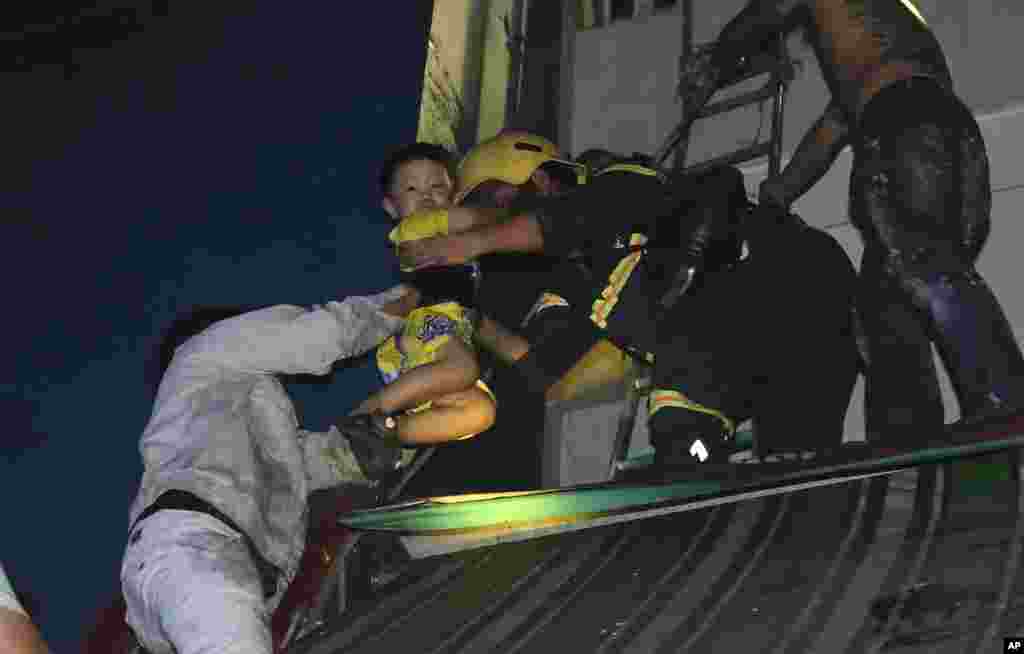 A boy is rescued from a condominium complex during a fire in Ho Chi Minh City, Vietnam. The fire killed over a dozen people, most of them died of suffocation or jumping from high floors.