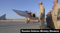 Russian service members line up after the landing of a Tupolev Tu-22M3 long-range bomber at the Hmeymim air base in west Syria, May 25, 2021.