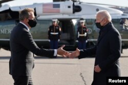 New Hampshire Governor Chris Sununu greets U.S. President Joe Biden as he arrives at Manchester-Boston Regional Airport in Manchester, New Hampshire, November 16, 2021.