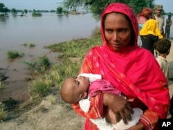 A mother carrying a child cries while evacuating her home along the flooded Chenab River, in Jhang, Pakistan, Sept. 10, 2014.