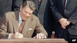 Le président Ronald Reagan, entouré de législateurs, signe une réforme historique de la taxe sur la pelouse sud de la Maison Blanche à Washington, 22 octobre 1986.