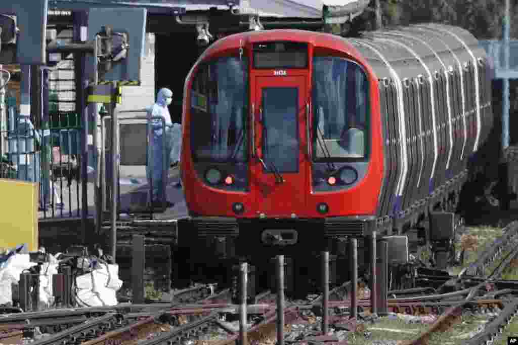 A police forensic officer stands beside the train where an incident happened, that police say they are investigating as a terrorist attack, at Parsons Green subway station in London.