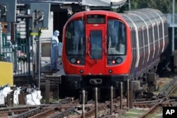 A police forensic officer stands beside the train where an incident happened, that police say they are investigating as a terrorist attack, at Parsons Green subway station in London, Sept. 15, 2017.