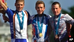 Russia's Viacheslav Ekimov, center, winner of the gold medal in the men's individual time trials, celebrates with Germany's silver medal winner Jan Ullrich, left, and U.S bronze medal winner Lance Armstrong at the cycling road course in Sydney, for the Summer Olympic Games, Sept. 30, 2000. 