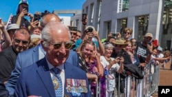 El rey Carlos III de Gran Bretaña recibe un ramo de rosas cuando se reúne con miembros del público frente al Parlamento en Canberra, Australia, el 21 de octubre de 2024.