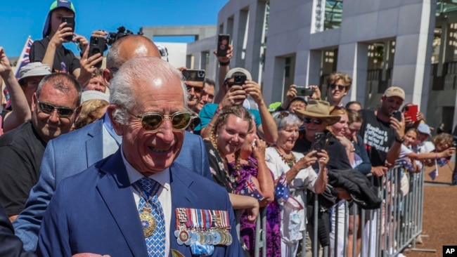 El rey Carlos III de Gran Bretaña recibe un ramo de rosas cuando se reúne con miembros del público frente al Parlamento en Canberra, Australia, el 21 de octubre de 2024.