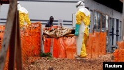 FILE - Health workers carry a newly admitted confirmed Ebola patient into a treatment centre in Butembo in the eastern Democratic Republic of Congo.