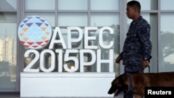 A military personnel walks past an APEC logo with his sniffer dog at the media center of the Asia-Pacific Economic Cooperation (APEC) summit in the capital city of Manila, Philippines November 17, 2015. 