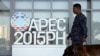 Seorang tentara melewati logo APEC dengan anjing pelacak di pusat media KTT APEC di Manila, Filipina (17/11). (Reuters/Edgar Su)