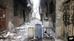Rubble and heavy damage remain on a deserted street during a government escorted visit to Yarmouk refugee camp in Damascus, Syria, April 9, 2015.