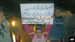 A girl whose father was killed during the recent shelling on Baba Amr district protests against Syria's President Bashar al-Assad in Al Qusour, Homs, March 3, 2012. The placard reads "The hypocritical international community wants to send aid to Baba Amr.