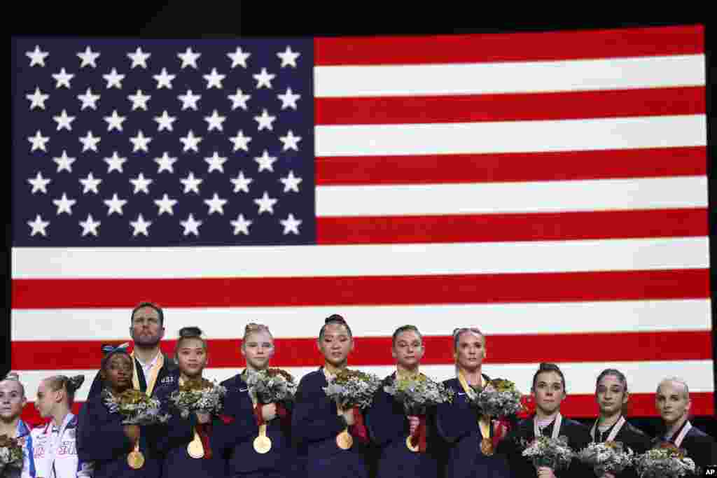 Team U.S.A. listens to the national anthem after winning the gold medal in the women&#39;s team final at the Gymnastics World Championships in Stuttgart, Germany.