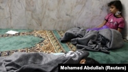 Girls who survived from what activists say is a gas attack rest inside a mosque in the Duma neighborhood of Damascus, Aug. 21, 2013. 