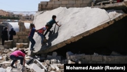 Anak anak pengungsi asal Suriah bermain diantara reruntuhan bangunan di kamp pengungsi sementara di kota perbatasan Lebanon, Arsal, pada 4 Juli 2019. (Foto: Reuters/Mohamed Azakir) 