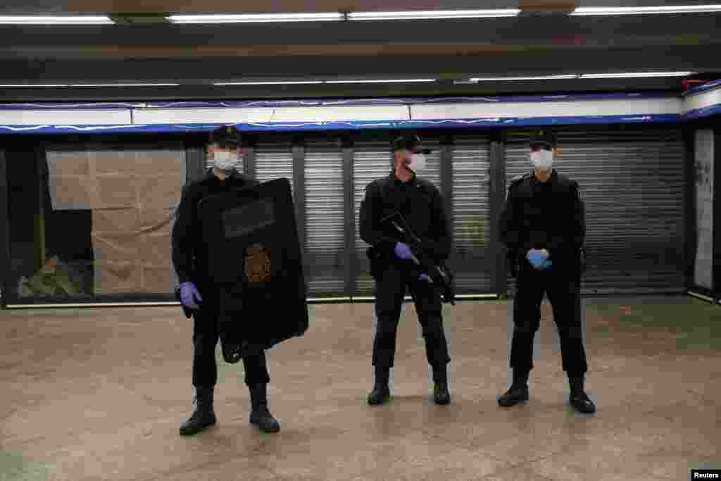 Agentes de la Policía Nacional se mantienen vigilantes en una estación del metro de Madrid, el lunes, día en que miles de personas se reincorporaron a sus trabajos en construcción y fábricas.