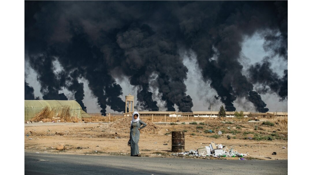 Smoke billows from burning tires to decrease visibility for Turkish warplanes on the outskirts of the town of Tal Tamr, Syria, along the border with Turkey in the northeastern Hassakeh province.