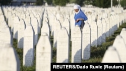 ARHIVA - Žena hoda između grobova u Potočarima, 11. jula 2017. (Foto: Reuters/Dado Ruvić)