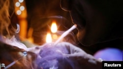 A drug user inhales "shabu," or methamphetamine, at a drug den in Manila, Philippines, Feb. 13, 2017.