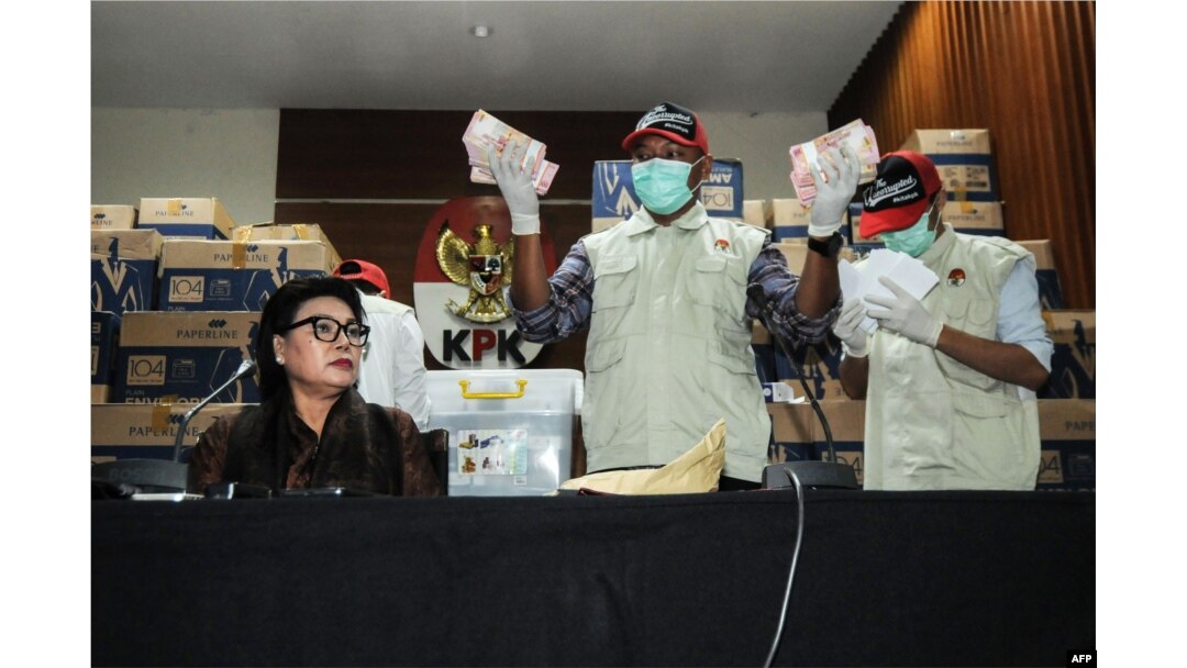 Komisioner KPK Basaria Panjaitan bersama para pejabat KPK dengan bukti uang tunai yang disita dari anggota DPR yang ditetapkan sebagai tersangka korupsi, di Jakarta, 17 April 2019. (Foto: AFP)