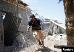 A fighter of Libyan forces allied with the U.N.-backed government runs for cover during a battle with Islamic State fighters in Sirte, Libya, July 31, 2016.